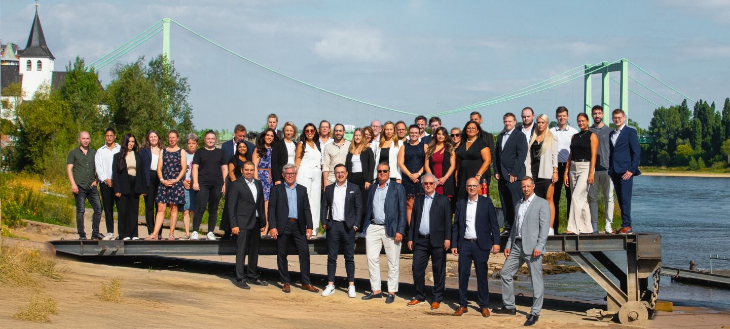 Das Team von NHP in Köln als Gruppenbild am Rhein vor der Rodenkirchener Brücke