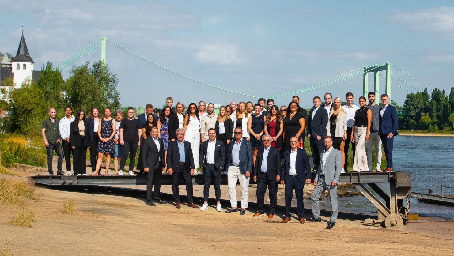 Das Team von NHP in Köln als Gruppenbild am Rhein vor der Rodenkirchener Brücke